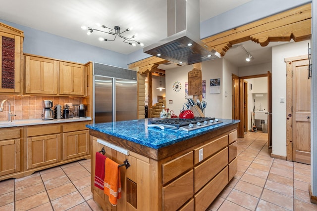 38 Calle Chamisa, Placitas, NM 87043 - kitchen featuring island exhaust hood, stainless steel appliances, light tile patterned floors, decorative backsplash, and rail lighting