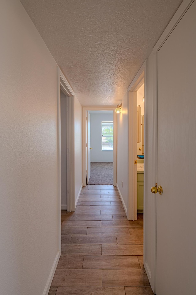 3742 Cattle Dr NE, Rio Rancho, NM 87144 - corridor featuring light wood-style flooring and a textured ceiling