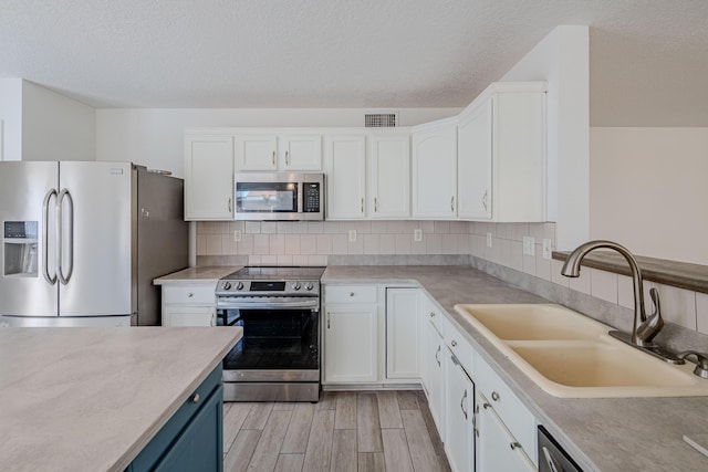 3742 Cattle Dr NE, Rio Rancho, NM 87144 - kitchen with stainless steel appliances, white cabinetry, blue cabinets, light wood-type flooring, and a textured ceiling