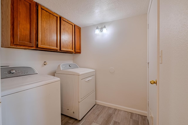 3742 Cattle Dr NE, Rio Rancho, NM 87144 - laundry area with washing machine and clothes dryer, light wood-type flooring, cabinet space, and a textured ceiling