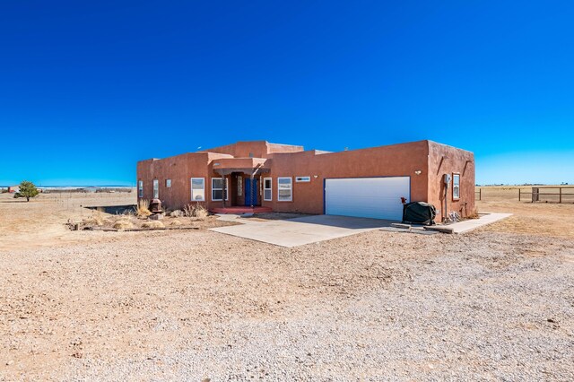300 Thompson, Moriarty, NM 87035 - pueblo-style house featuring concrete driveway, a garage, and stucco siding