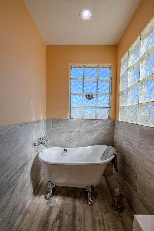 300 Thompson, Moriarty, NM 87035 - bathroom featuring tile walls, a freestanding bath, wood finished floors, and a wainscoted wall