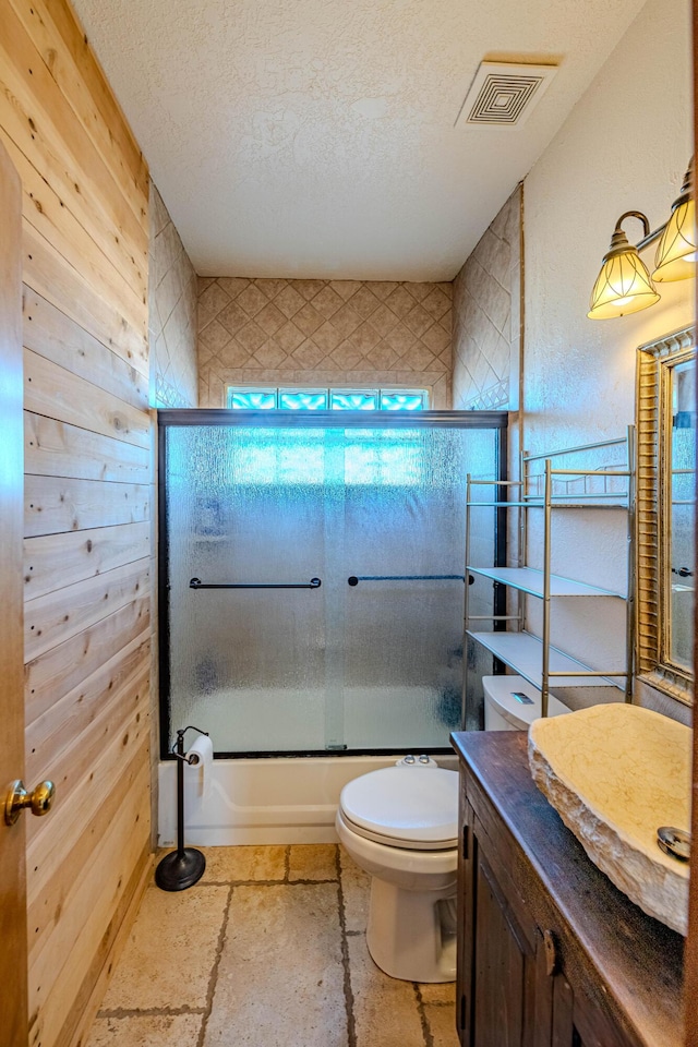 300 Thompson, Moriarty, NM 87035 - full bathroom with vanity, combined bath / shower with glass door, a textured ceiling, and stone tile floors