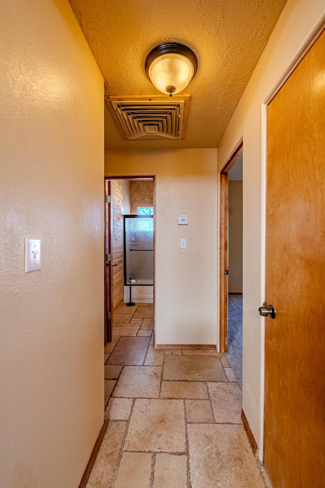 300 Thompson, Moriarty, NM 87035 - corridor with stone tile floors and a textured ceiling