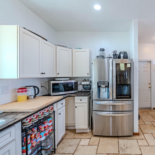300 Thompson, Moriarty, NM 87035 - kitchen with stainless steel appliances, stone tile flooring, white cabinetry, recessed lighting, and dark countertops