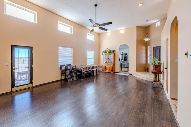 300 Thompson, Moriarty, NM 87035 - living area featuring a ceiling fan, arched walkways, healthy amount of natural light, wood finished floors, and a towering ceiling