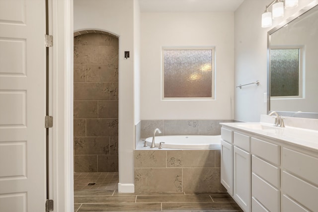 205 Silent Spring Dr NE, Rio Rancho, NM 87124 - full bathroom featuring a bath, vanity, tiled shower, and wood finish floors