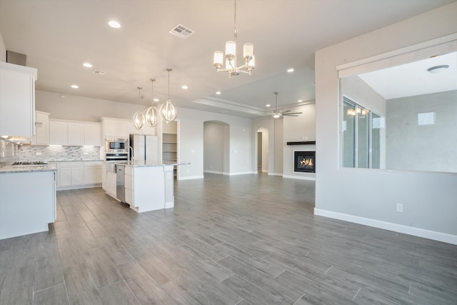 205 Silent Spring Dr NE, Rio Rancho, NM 87124 - kitchen with open floor plan, appliances with stainless steel finishes, a chandelier, arched walkways, and recessed lighting