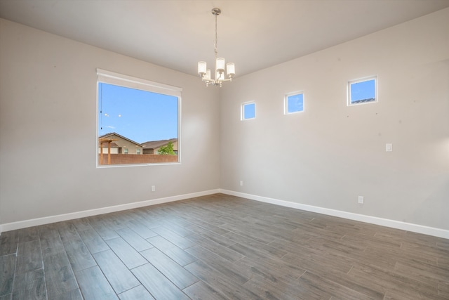 205 Silent Spring Dr NE, Rio Rancho, NM 87124 - unfurnished room with a chandelier and dark wood-style flooring