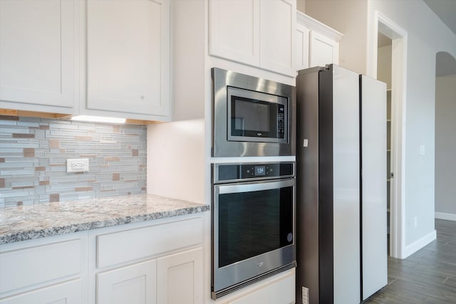 205 Silent Spring Dr NE, Rio Rancho, NM 87124 - kitchen featuring stainless steel appliances, white cabinetry, backsplash, light stone countertops, and wood finished floors