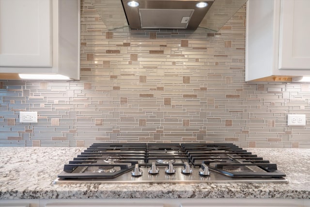 205 Silent Spring Dr NE, Rio Rancho, NM 87124 - kitchen view of stainless steel gas cooktop, exhaust hood, decorative backsplash, and white cabinets