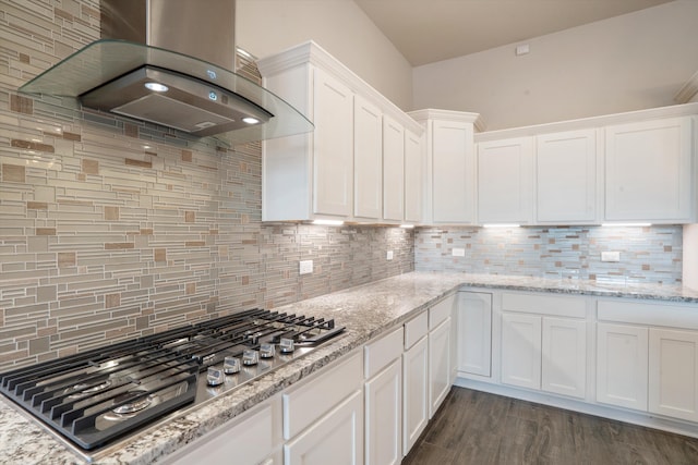 205 Silent Spring Dr NE, Rio Rancho, NM 87124 - kitchen with wall chimney range hood, stainless steel gas cooktop, white cabinetry, and backsplash