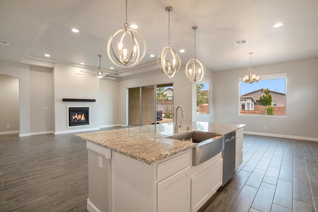 205 Silent Spring Dr NE, Rio Rancho, NM 87124 - kitchen with a chandelier, stainless steel dishwasher, a lit fireplace, a center island with sink, and recessed lighting