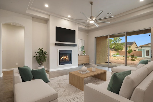 205 Silent Spring Dr NE, Rio Rancho, NM 87124 - living room with recessed lighting, ceiling fan, a glass covered fireplace, wood finished floors, and arched walkways