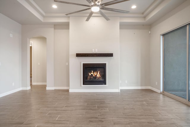 205 Silent Spring Dr NE, Rio Rancho, NM 87124 - unfurnished living room featuring a raised ceiling, ceiling fan, wood finished floors, arched walkways, and recessed lighting