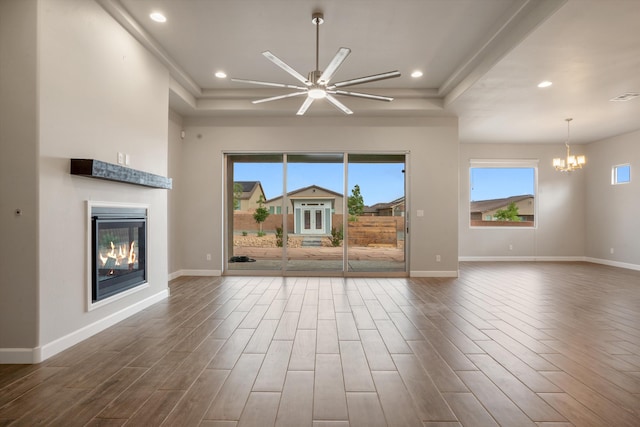 205 Silent Spring Dr NE, Rio Rancho, NM 87124 - unfurnished living room with dark wood-style floors, a glass covered fireplace, a chandelier, ceiling fan, and recessed lighting
