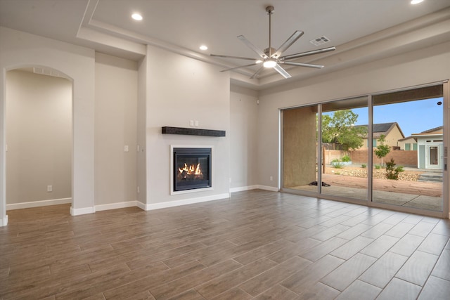 205 Silent Spring Dr NE, Rio Rancho, NM 87124 - unfurnished living room featuring a ceiling fan, arched walkways, recessed lighting, wood finished floors, and a glass covered fireplace