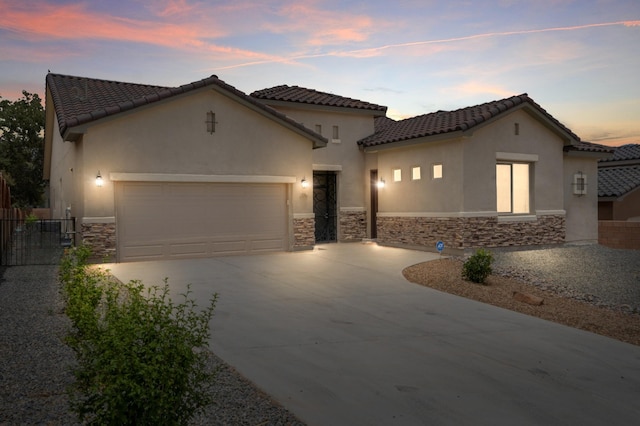 205 Silent Spring Dr NE, Rio Rancho, NM 87124 - mediterranean / spanish-style house featuring stone siding, a garage, concrete driveway, and stucco siding