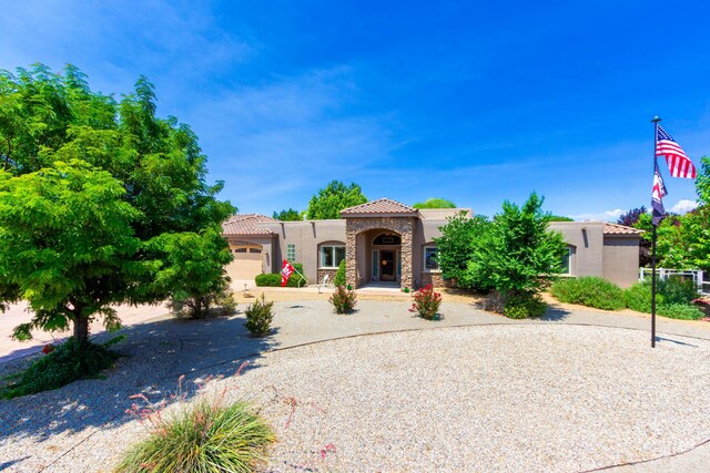 930 Titus Loop, Bosque Farms, NM 87068 - mediterranean / spanish-style home with a tile roof, stucco siding, an attached garage, and concrete driveway