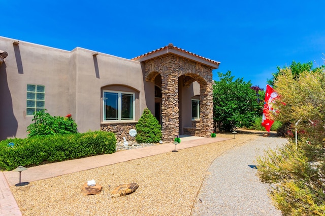 930 Titus Loop, Bosque Farms, NM 87068 - view of front of home featuring stucco siding, stone siding, and a tiled roof