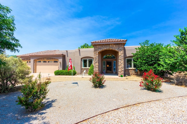930 Titus Loop, Bosque Farms, NM 87068 - mediterranean / spanish-style house with stucco siding, an attached garage, stone siding, a tile roof, and driveway