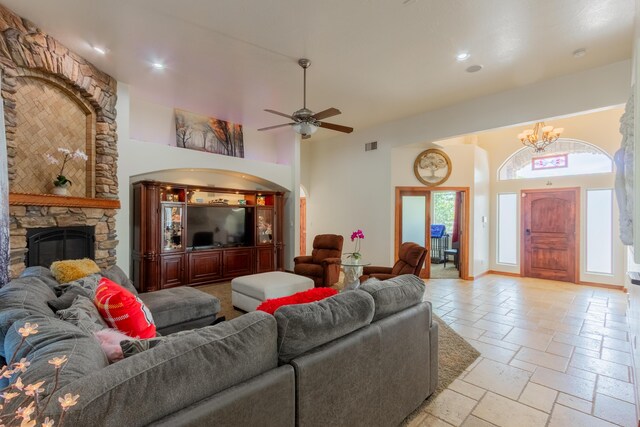 930 Titus Loop, Bosque Farms, NM 87068 - living room with a high ceiling, stone tile flooring, a chandelier, a fireplace, and a ceiling fan
