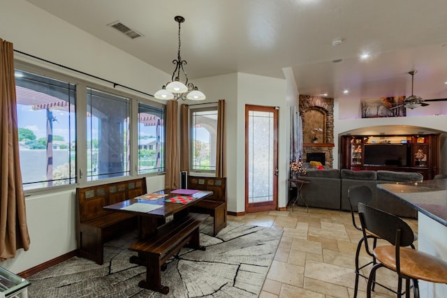 930 Titus Loop, Bosque Farms, NM 87068 - dining area featuring stone tile flooring, a stone fireplace, and a ceiling fan