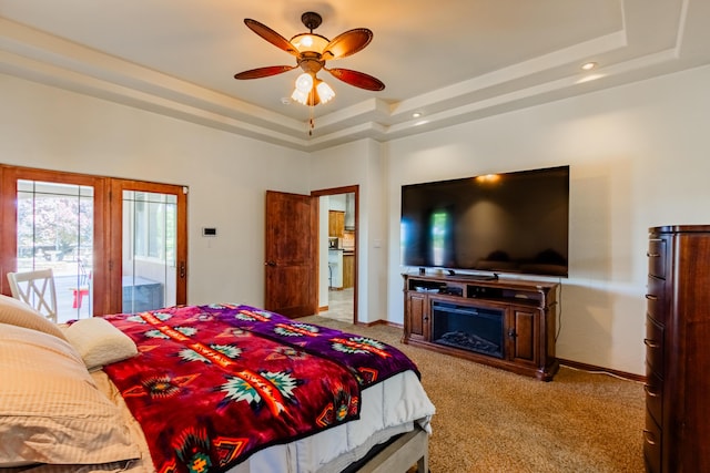 930 Titus Loop, Bosque Farms, NM 87068 - bedroom featuring a raised ceiling, carpet floors, a glass covered fireplace, access to outside, and a ceiling fan