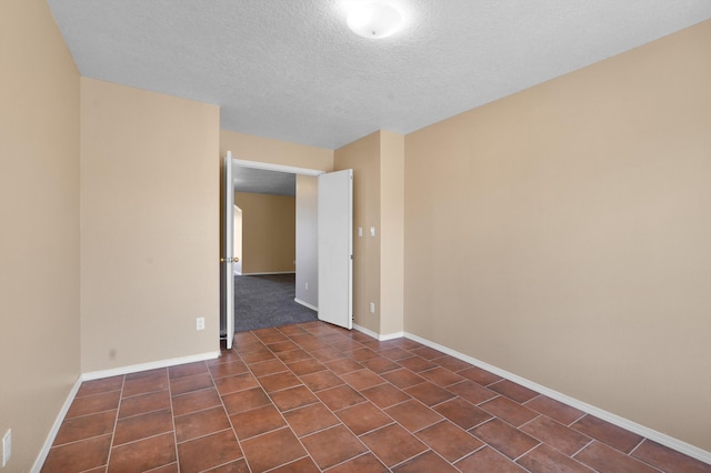 1944 Sierra Norte Loop NE, Rio Rancho, NM 87144 - empty room featuring a textured ceiling and dark tile patterned flooring