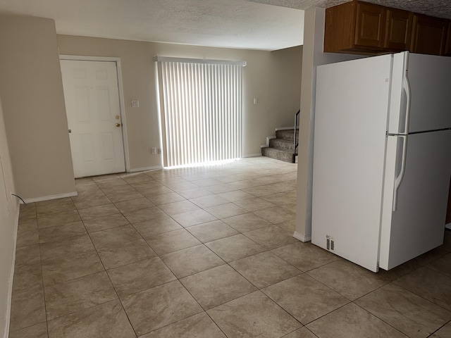 8333 Comanche Rd NE Unit 10B, Albuquerque, NM 87110 - kitchen featuring freestanding refrigerator, light tile patterned flooring, and a textured ceiling