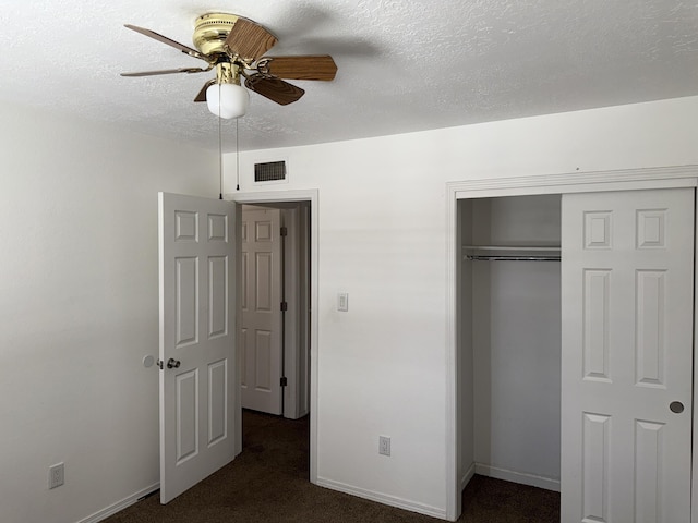 8333 Comanche Rd NE Unit 10B, Albuquerque, NM 87110 - unfurnished bedroom with dark colored carpet, a closet, a textured ceiling, and ceiling fan