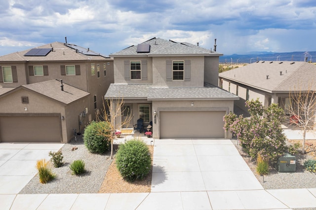 4823 Blackburn Rd NE, Rio Rancho, NM 87144 - view of front facade with concrete driveway, stucco siding, roof with shingles, solar panels, and an attached garage