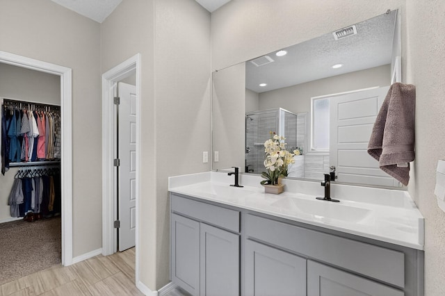 4823 Blackburn Rd NE, Rio Rancho, NM 87144 - bathroom featuring a shower stall, double vanity, and a spacious closet