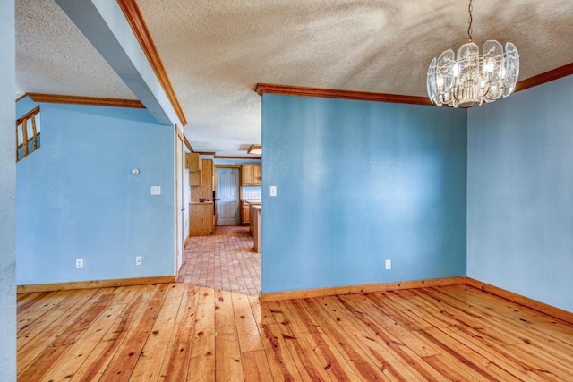 10 Quail Run Rd, Tijeras, NM 87059 - unfurnished room with a textured ceiling, a chandelier, crown molding, and hardwood / wood-style floors