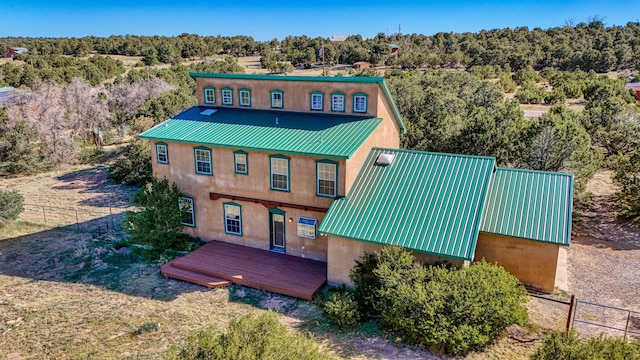 10 Quail Run Rd, Tijeras, NM 87059 - back of property featuring stucco siding, a metal roof, and a wooden deck