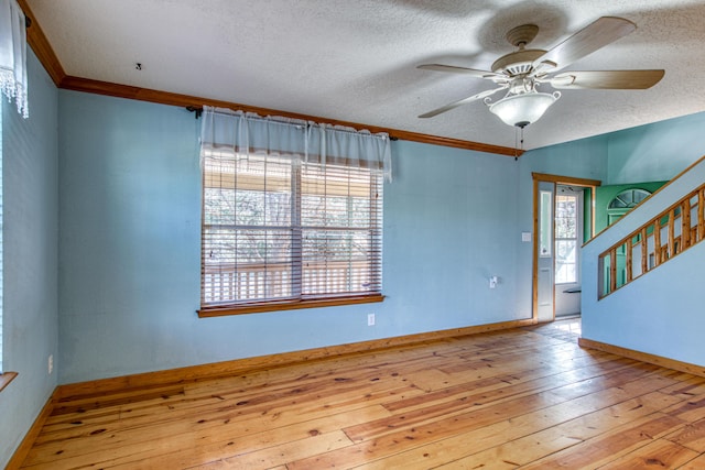 10 Quail Run Rd, Tijeras, NM 87059 - spare room featuring hardwood / wood-style flooring, a textured ceiling, ceiling fan, stairway, and ornamental molding