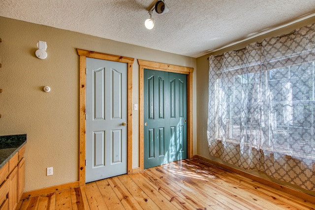 10 Quail Run Rd, Tijeras, NM 87059 - foyer featuring light wood finished floors, a textured ceiling, and a textured wall