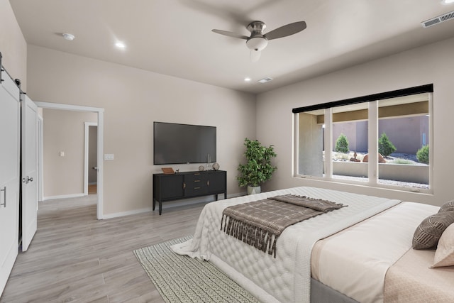 7 Aztec Ct, Placitas, NM 87043 - bedroom featuring a barn door, light wood-style flooring, recessed lighting, and a ceiling fan
