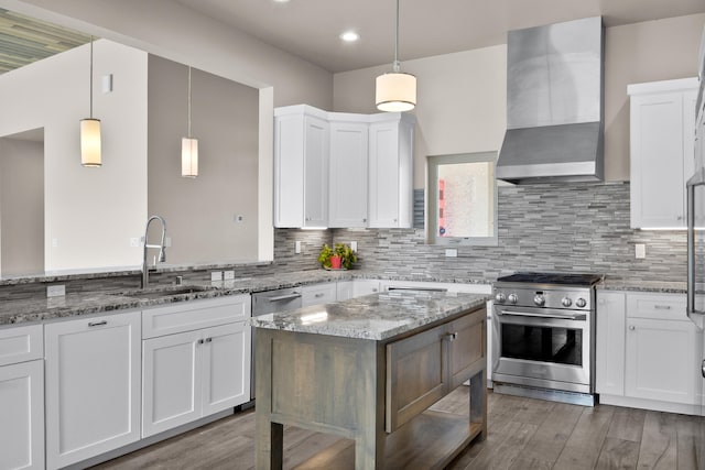 7 Aztec Ct, Placitas, NM 87043 - kitchen featuring stainless steel appliances, wall chimney range hood, light wood-style floors, white cabinetry, and recessed lighting