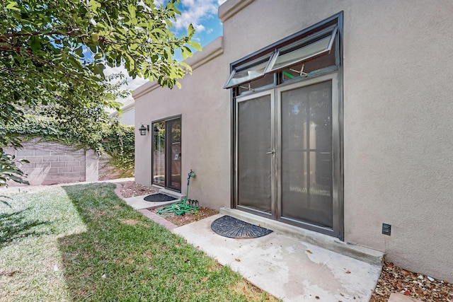 6205 Peachtree Pl NE, Albuquerque, NM 87111 - doorway to property featuring stucco siding and a lawn