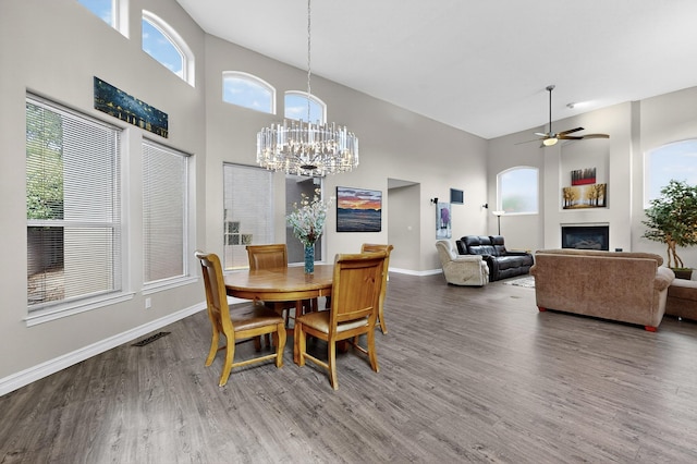 6205 Peachtree Pl NE, Albuquerque, NM 87111 - dining room featuring a towering ceiling, wood finished floors, a fireplace, ceiling fan, and a chandelier