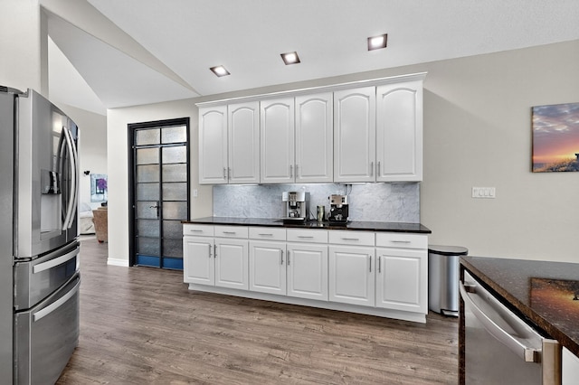 6205 Peachtree Pl NE, Albuquerque, NM 87111 - kitchen featuring appliances with stainless steel finishes, vaulted ceiling, light wood-style flooring, backsplash, and white cabinets