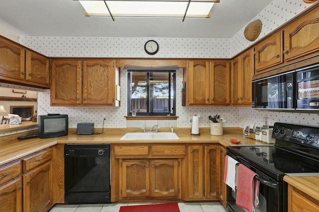 11213 Paseo Del Oso, Albuquerque, NM 87111 - kitchen with black appliances, light countertops, brown cabinetry, and light tile patterned floors