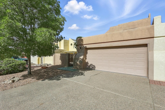 11213 Paseo Del Oso, Albuquerque, NM 87111 - pueblo revival-style home with stucco siding, concrete driveway, and a garage