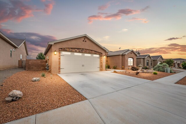 2660 Firewheel Ave SW, Los Lunas, NM 87031 - ranch-style house featuring stucco siding, concrete driveway, an attached garage, and a gate