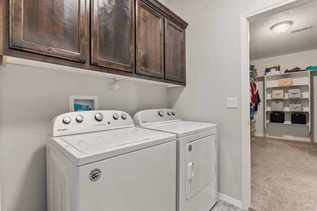 2660 Firewheel Ave SW, Los Lunas, NM 87031 - laundry room featuring washer and clothes dryer, light colored carpet, cabinet space, and a textured ceiling