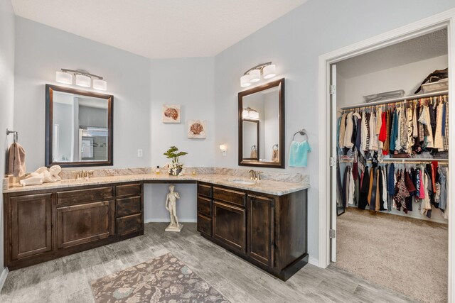 2660 Firewheel Ave SW, Los Lunas, NM 87031 - full bath with double vanity, a spacious closet, and wood finished floors