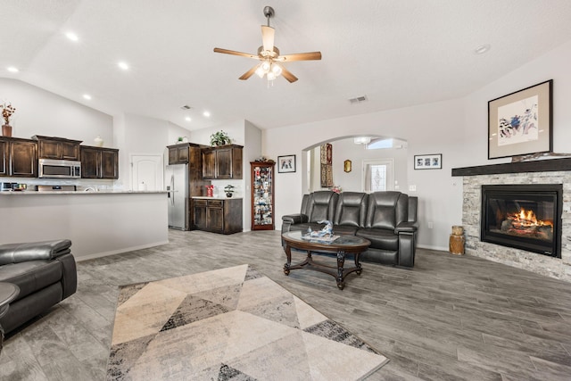 2660 Firewheel Ave SW, Los Lunas, NM 87031 - living area featuring arched walkways, vaulted ceiling, recessed lighting, ceiling fan, and a fireplace