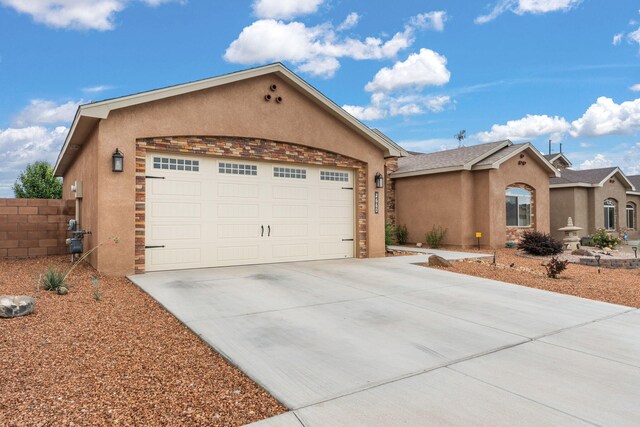 2660 Firewheel Ave SW, Los Lunas, NM 87031 - view of front of property with stucco siding, concrete driveway, and a garage