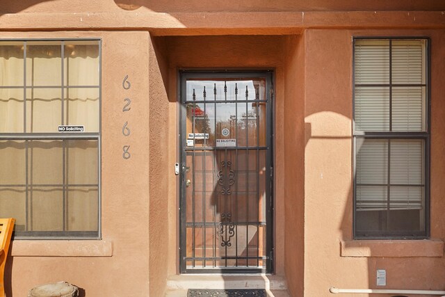 6268 Apache Plume Rd NE, Rio Rancho, NM 87144 - doorway to property featuring stucco siding